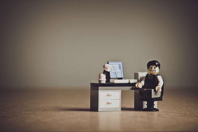 Legomännchen am Schreibtisch suggeriert das Thema Prokrastination überwinden und die Frage was ist Prokrastination